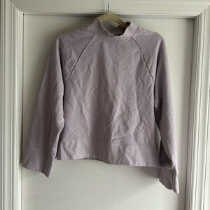 On lavender mockneck sweatshirt
